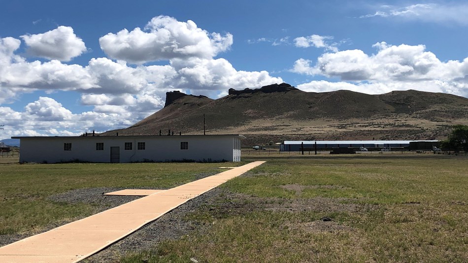 Several long buildings in a high desert near a bluff