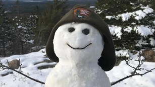 Snowman wearing a ranger winter hat
