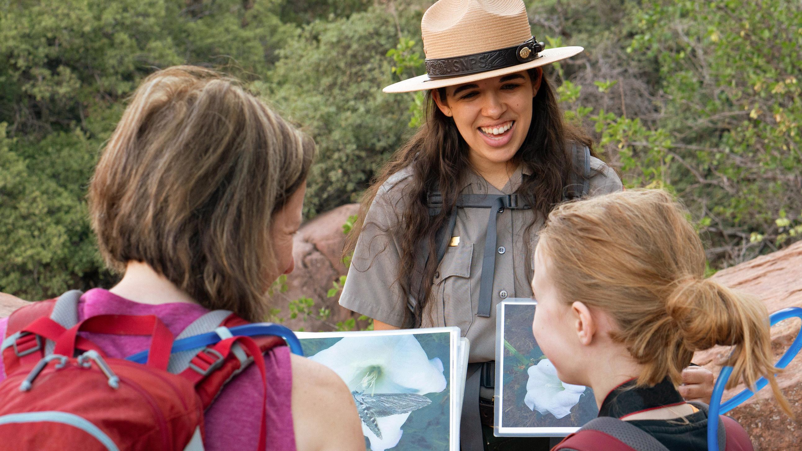 Park ranger showing two visitors interpretive signs