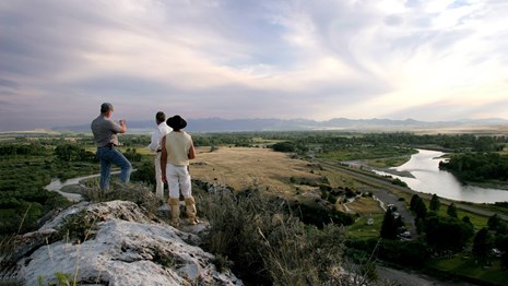 Three people overlooking a river valley
