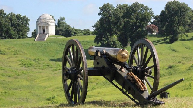 19th-century cannon pointing towards a monument