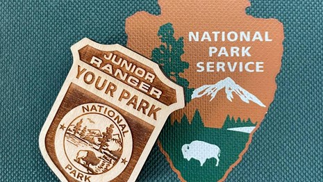 Junior Ranger badge and the National Park Service arrowhead logo