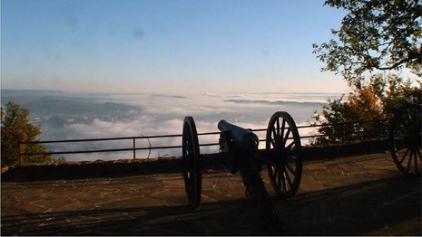 Canon on a bluff overlooking a city