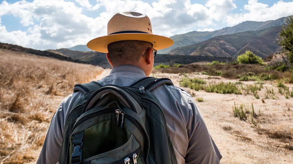 Ranger walking on a trail in a desert