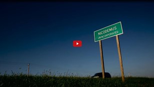 Screenshot from a film of a road sign for the town of Nicodemus