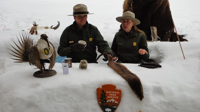 Rangers and props talking from a desk made of snow outside