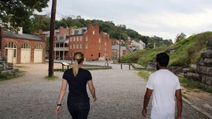 Two hikers walking into a historic town