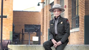 Ranger Betty Soskin sitting near museum exhibits