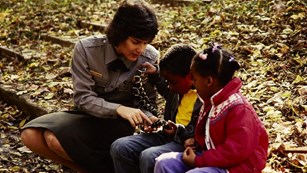 Historical photo of ranger talking to two kids