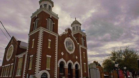 Large red brick church with two spires