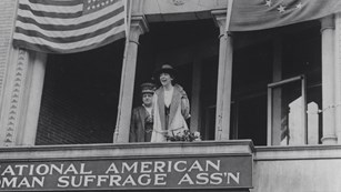 Black and white historic photo of two suffragists on a balcony