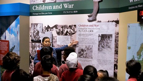 Ranger talking to school group in an exhibit about kids during World War II
