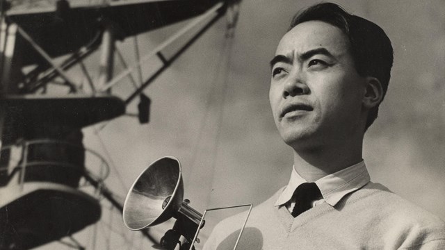 Black and white photo of a photographer holding a camera