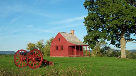 Cannon and historic barn in a field