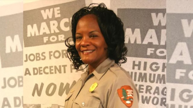 Ranger Judy Forte standing in front of historical demonstration signs