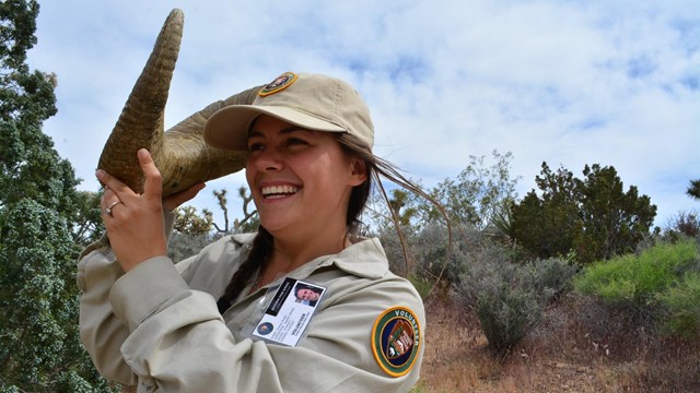 Volunteer holding a horn of an animal in the desert