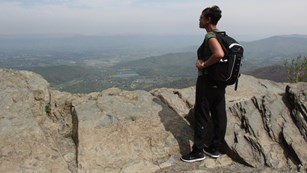 Visitor standing at an overview of a valley