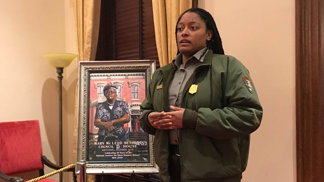 Ranger giving a talk next to a portrait of Mary McLeod Bethune