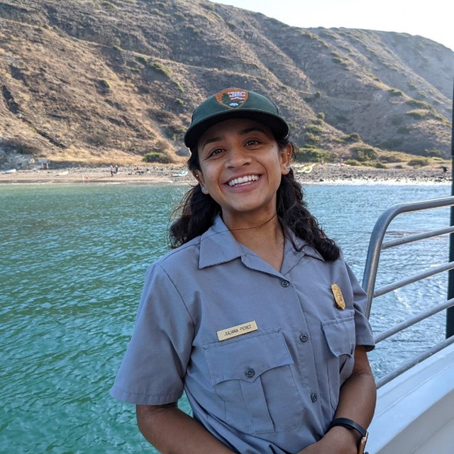 Portrait of a ranger outside by water and mountains 