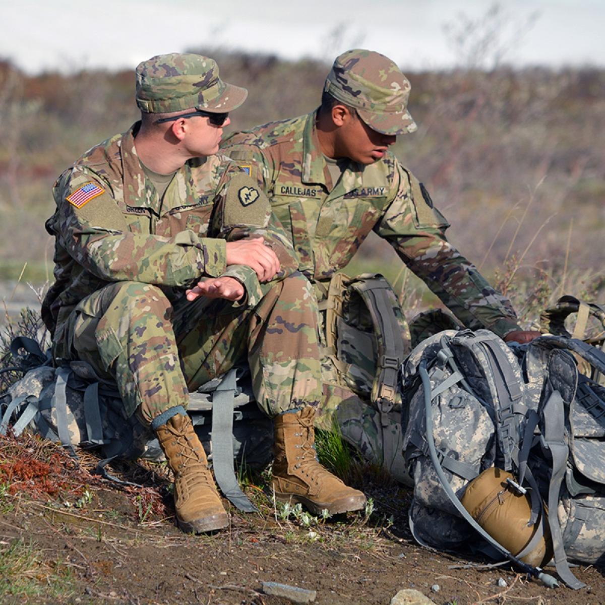 Two army soldiers sitting on ruck sacks