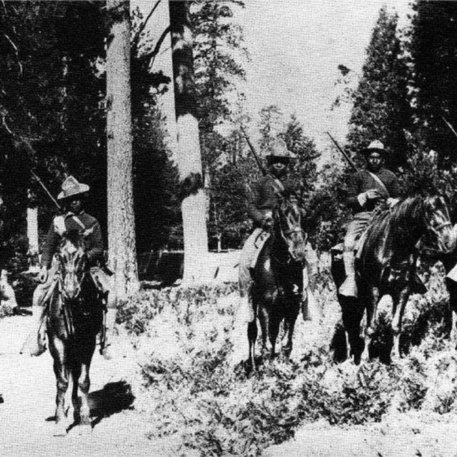 Historic black and white photograph of mounted Buffalo Soldiers at Yosemite