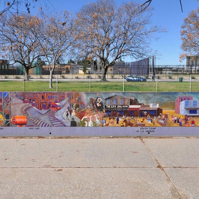 Long city park wall with a detailed mural