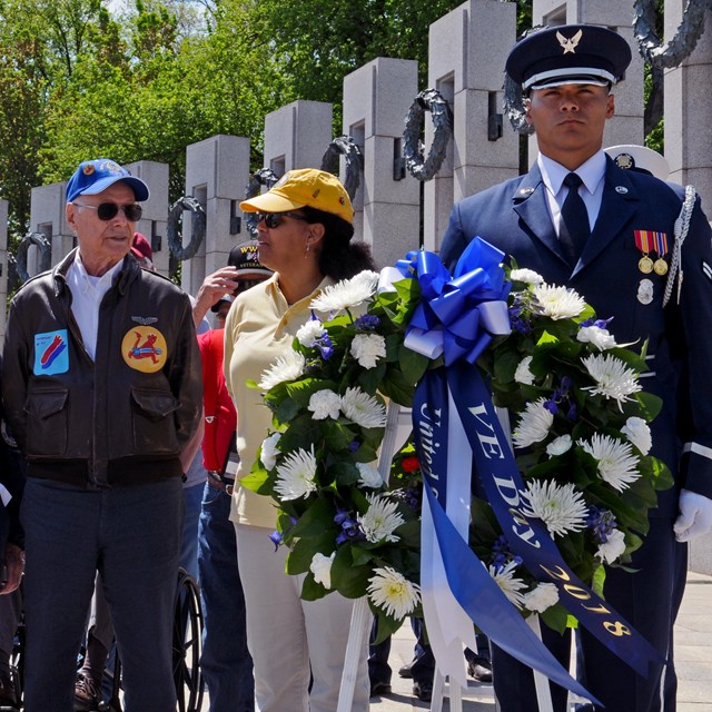 Active duty and retired military veterans standing by a wreath