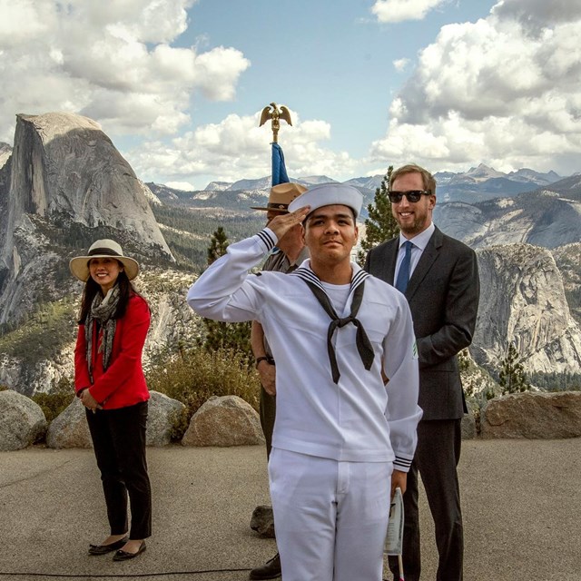 Sailor saluting with scenic mountain range in the background