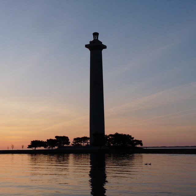 Tall tower structure on an island at dusk
