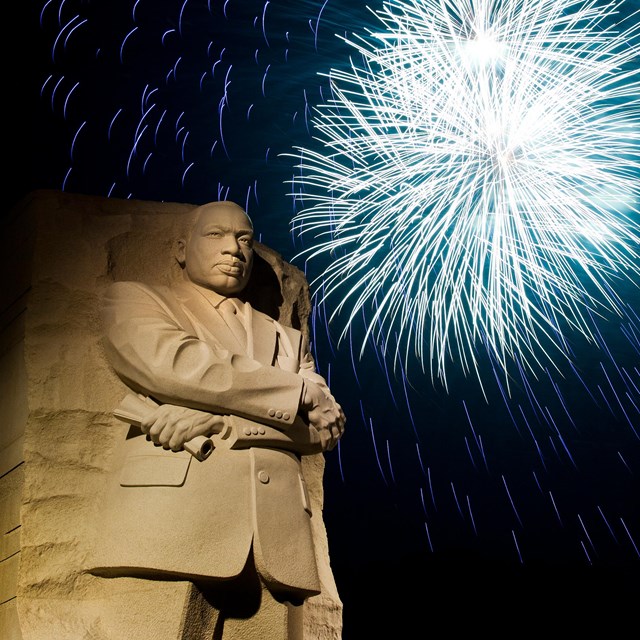 Fireworks over a statue of Martin Luther King Jr.