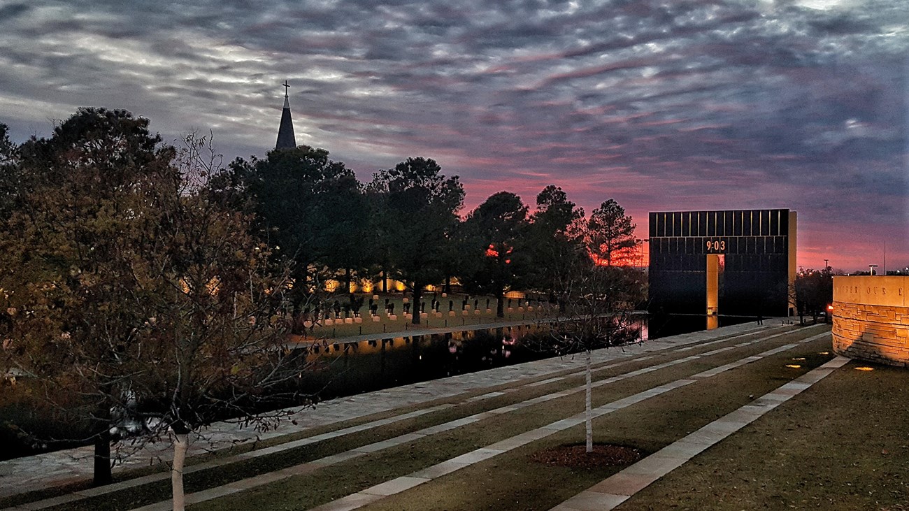 The view of the sun setting behind the 9:03 gate from beside the Survivor Tree. 