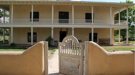 large yellow house with open gate