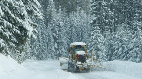 Snow plow works to clear heavy snow on Hurricane Ridge Road.