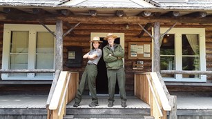 Two national park rangers stand on the patio of the Storm King ranger station.