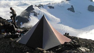 A tent sits in a mountainous area.