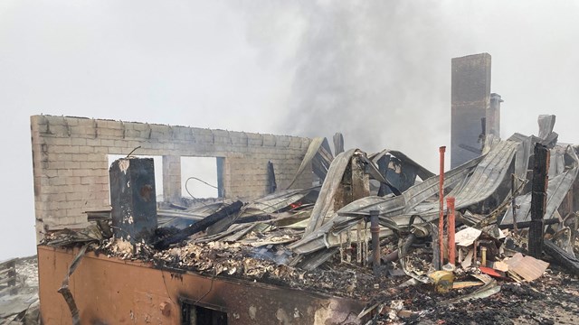 The badly burned, smoking remains of a building.