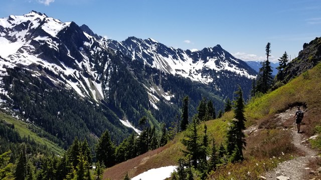 A trail in the alpine with views of distant mountains. 