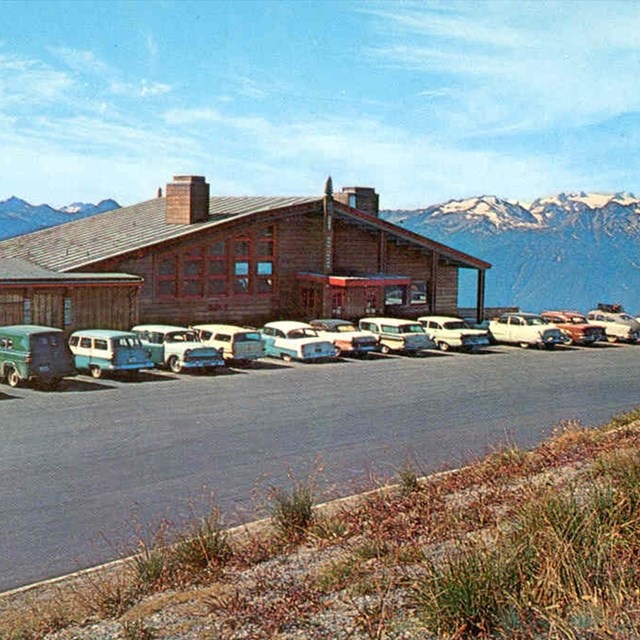 An archival photo of cars from the 1950s outside a mountain lodge.