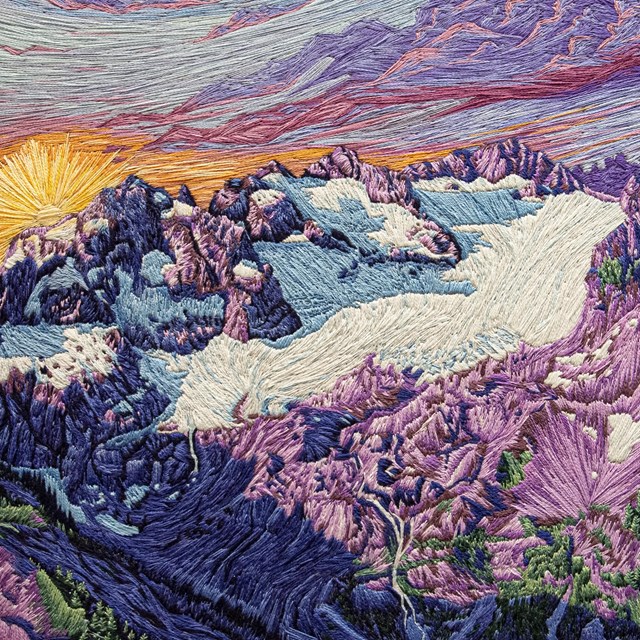 A meticulously embroidered sunset over a mountain peak and glacier.