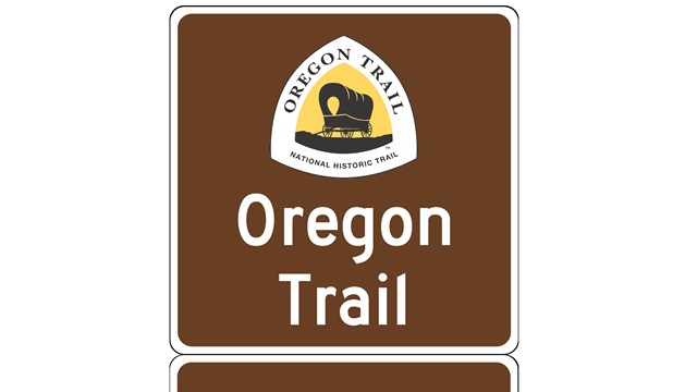 A trail sign with "Oregon Trail" and a logo design.