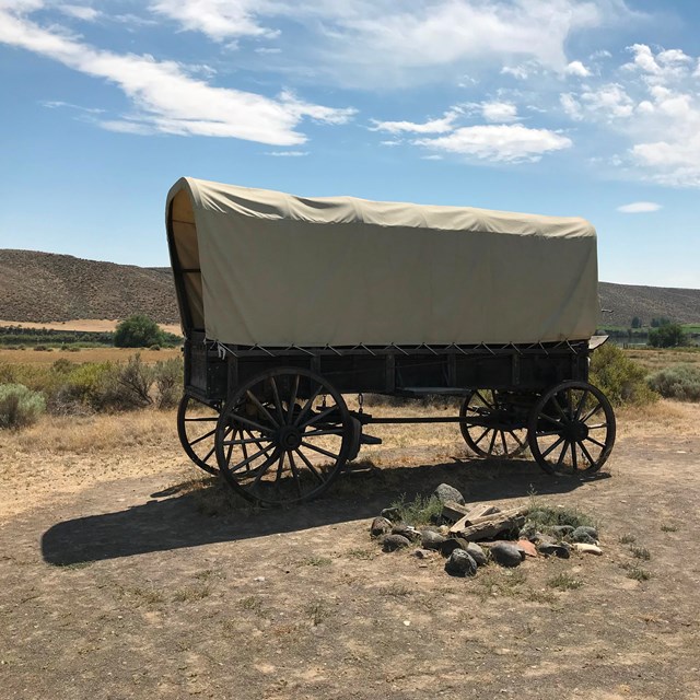 A covered wagon in a desert setting.