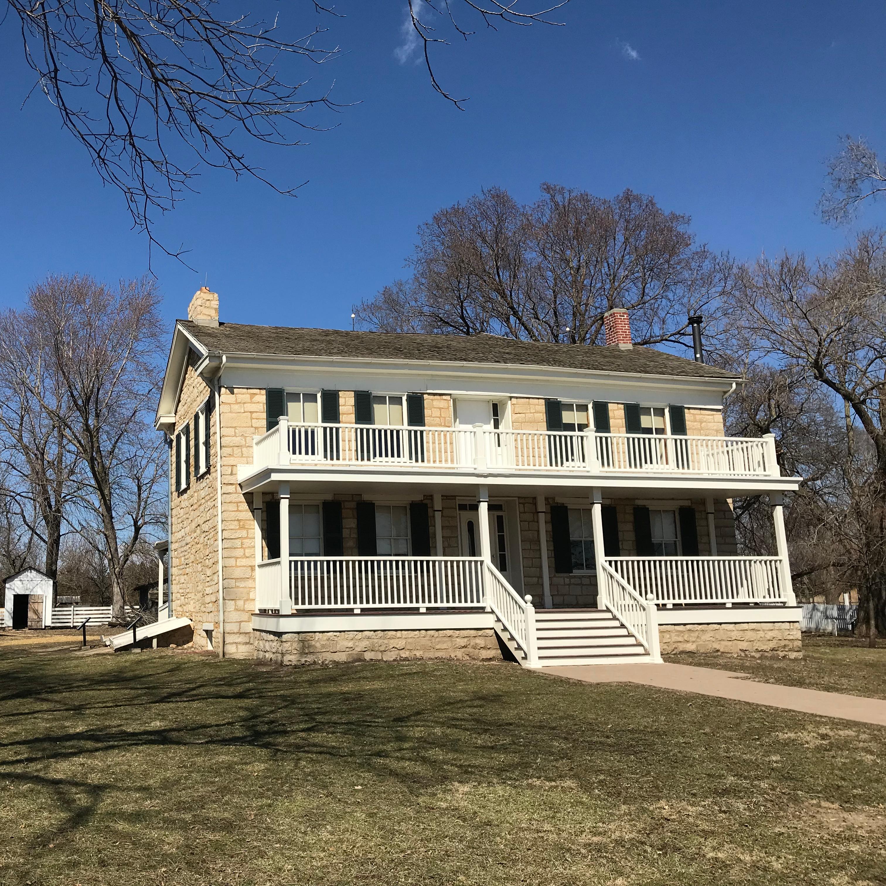A historic two-story wooden home with a large front porch.