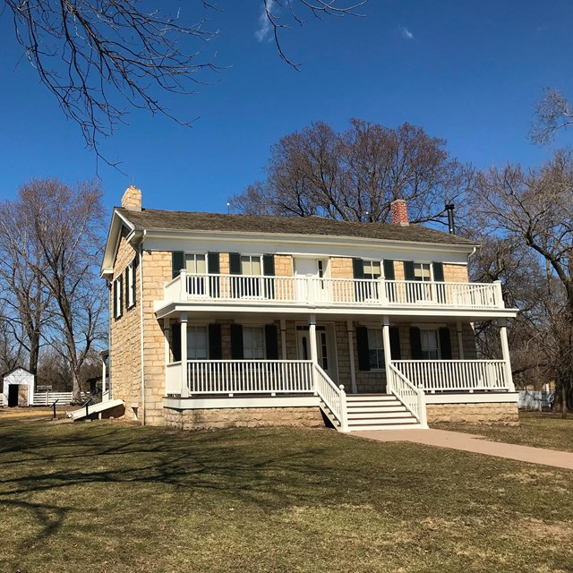 A historic two-story wooden home with a large front porch.