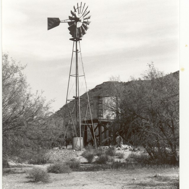 early park ranger takes notes above a mine shaft