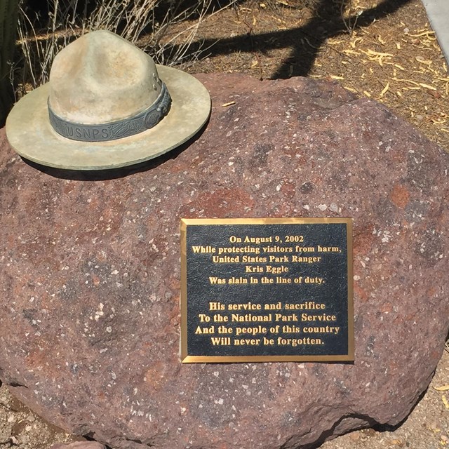 picture of the Eggle Memorial, stone flat hat and plaque on a rock