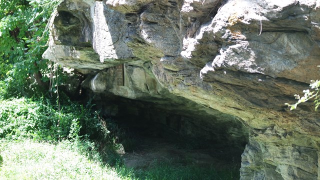 A large rock over hang with dark area beneath