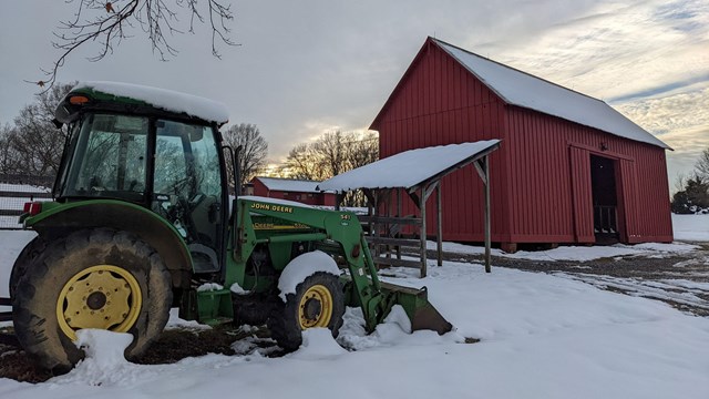 A big green tractor on a snowy day