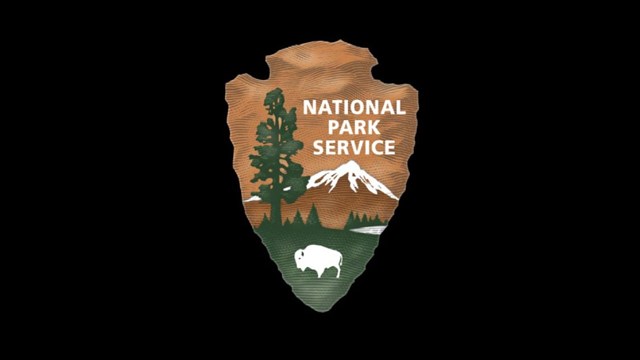 A National Park Service Arrowhead on a black background