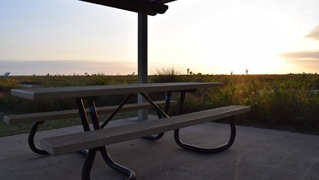 Picnic table underneath the shade of a shelter