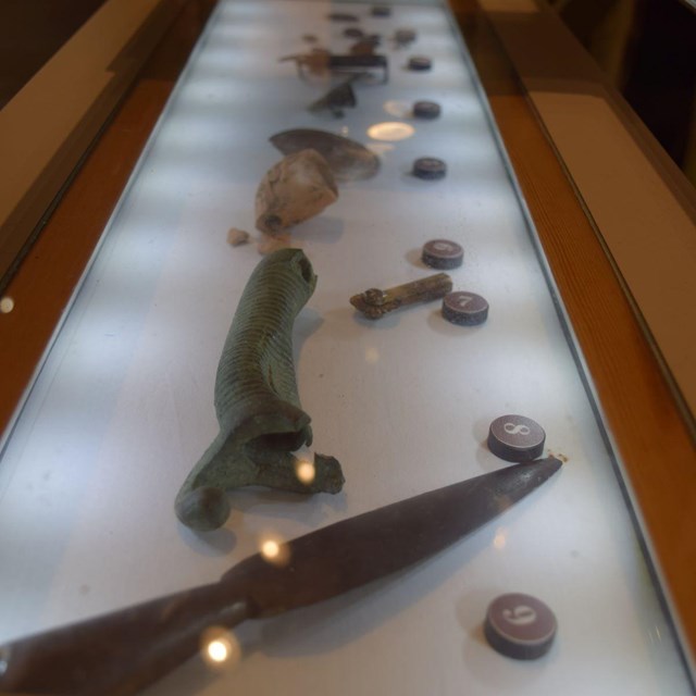 Closeup of battlefield artifacts in a display case.